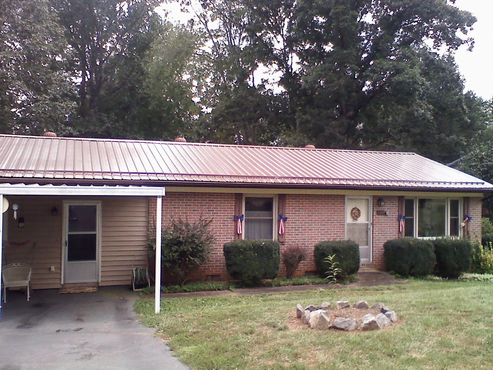 Bronze metal roof and carport on a brick ranch home — Roof Repair work by our crew in Stevensville